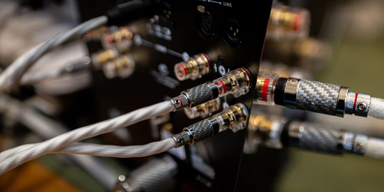 Speaker terminals and cable connections at the back of an amplifier.