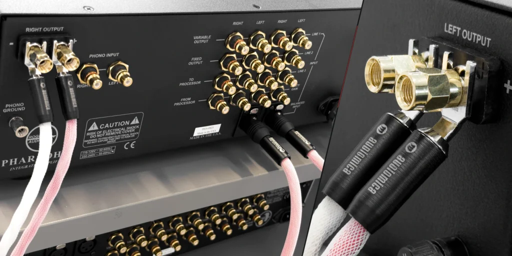 An amplifier rear panel with audio inputs and speaker terminals.